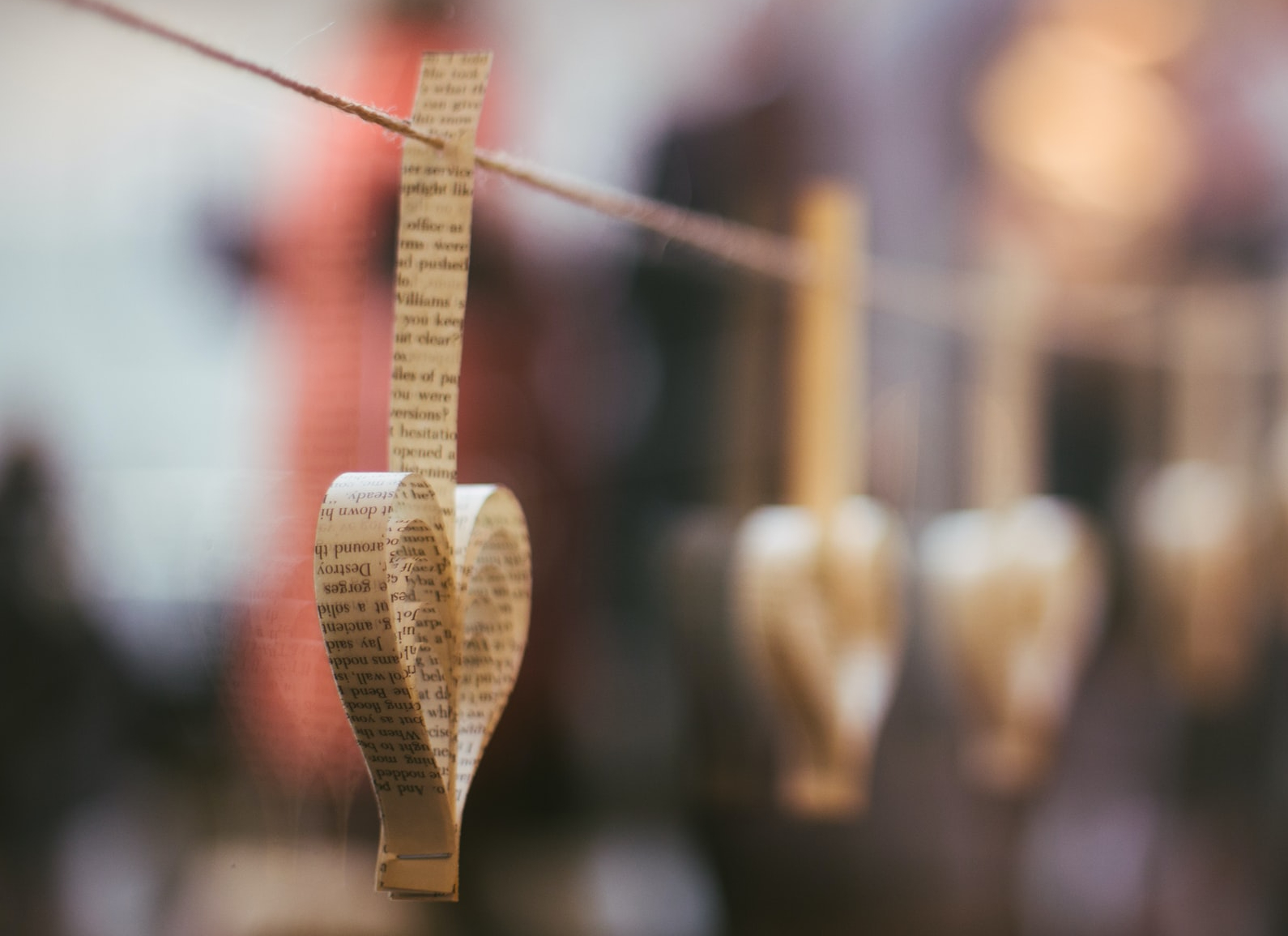 Hearts made from strips of book pages hanging in a line