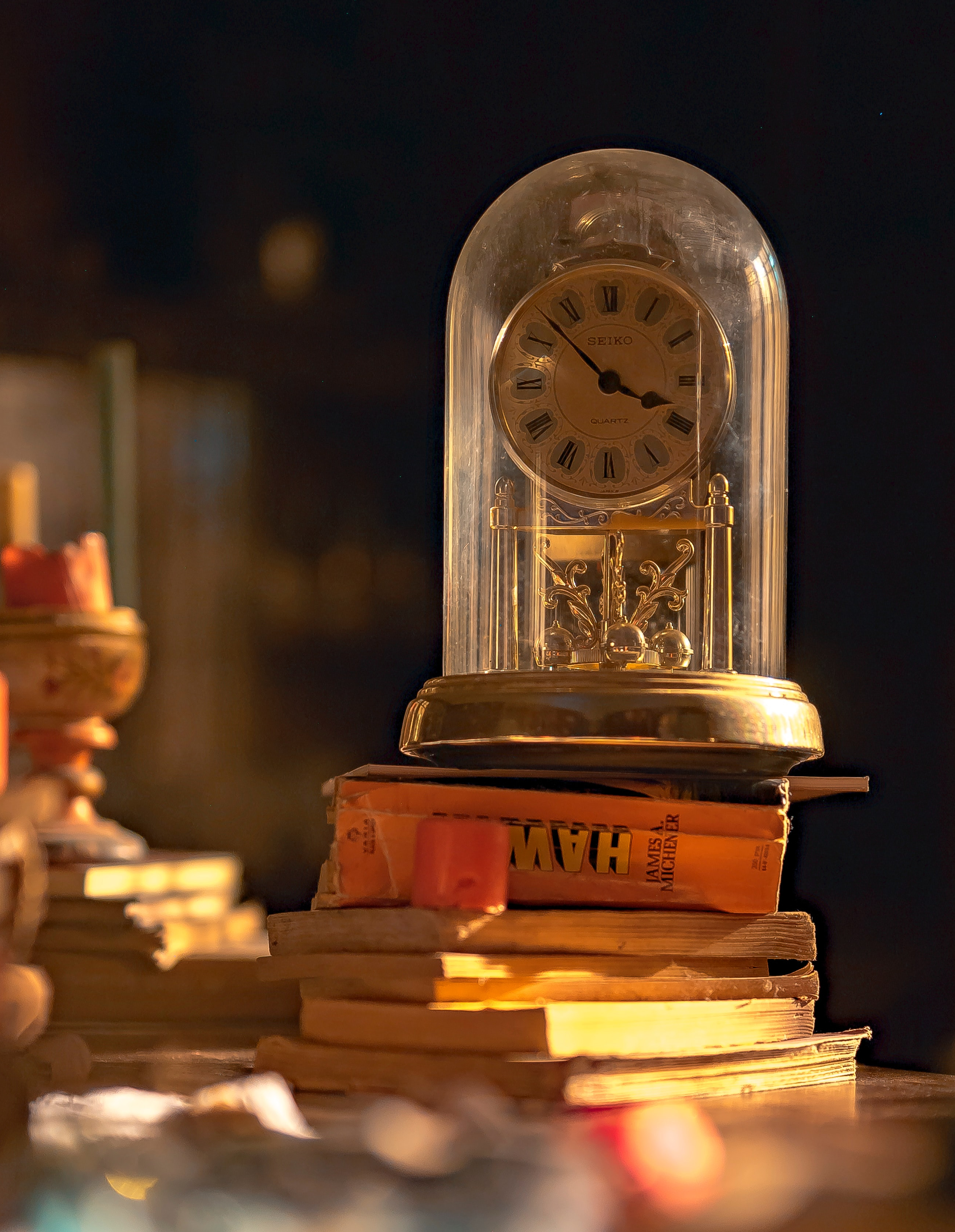 gold vintage table clock under cloche on books