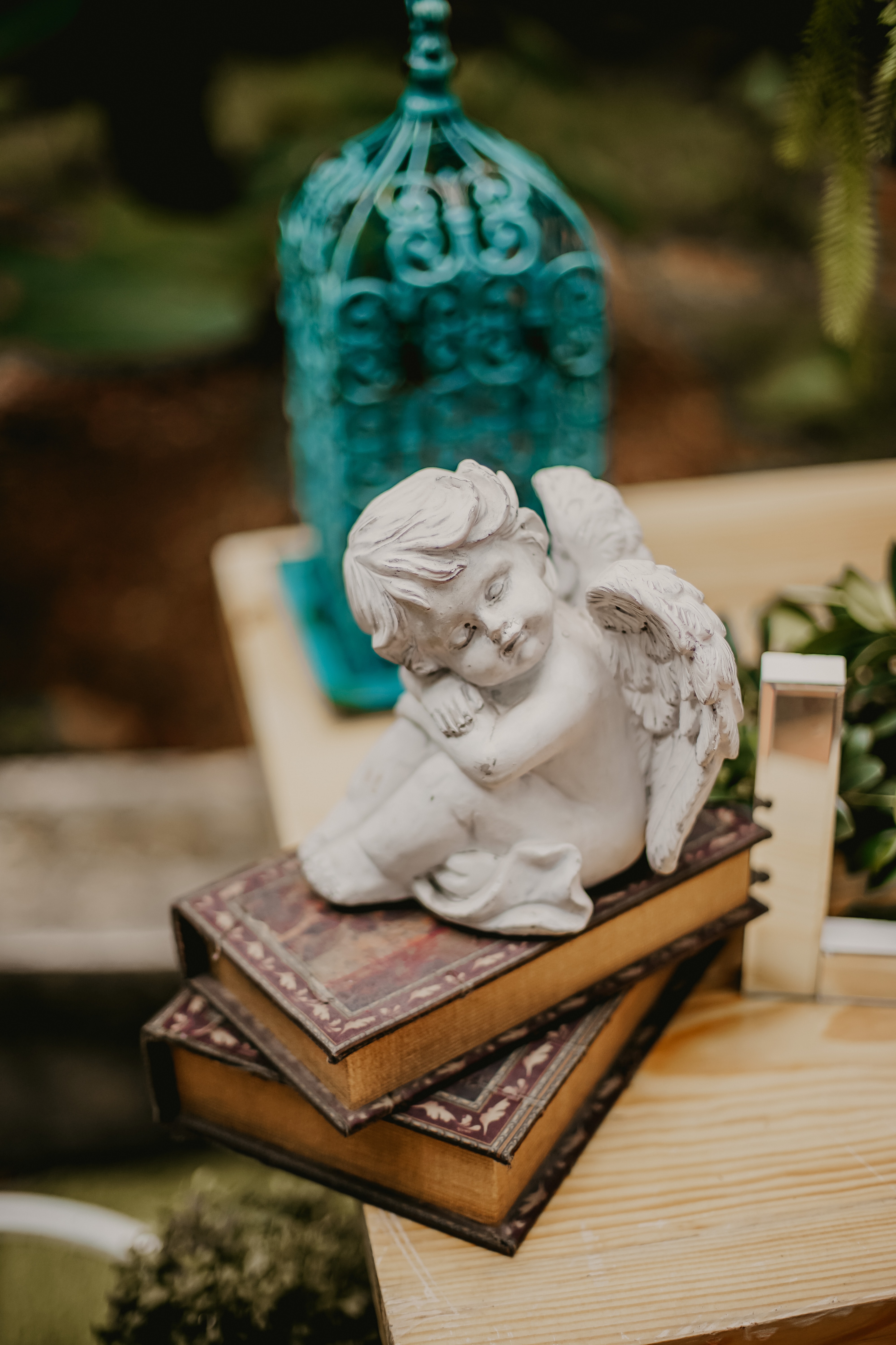 small white ceramic angel on top of vintage books