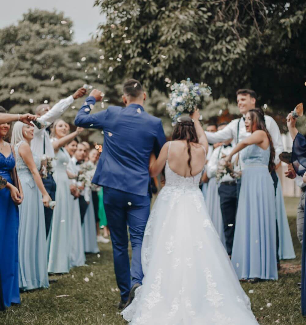 Bride and groom have confetti thrown at them by their guests
