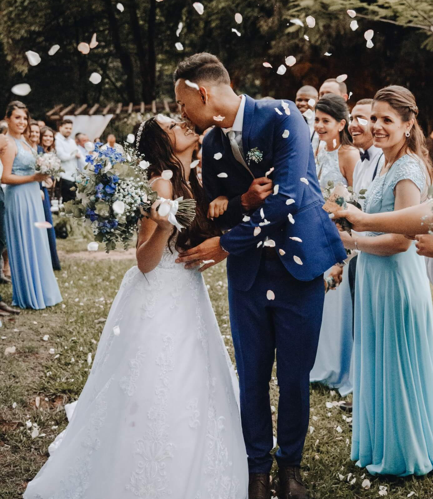 Bride and groom kissing after having confetti thrown at them