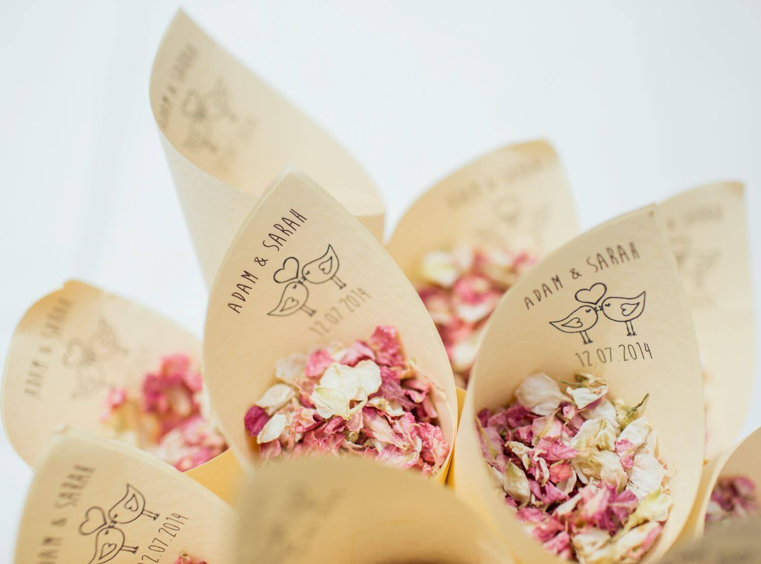 personalised paper cones filled with white and pink dried petal confetti